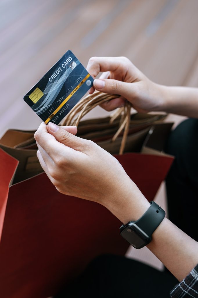 Young woman holding credit cards in hand at shopping mall